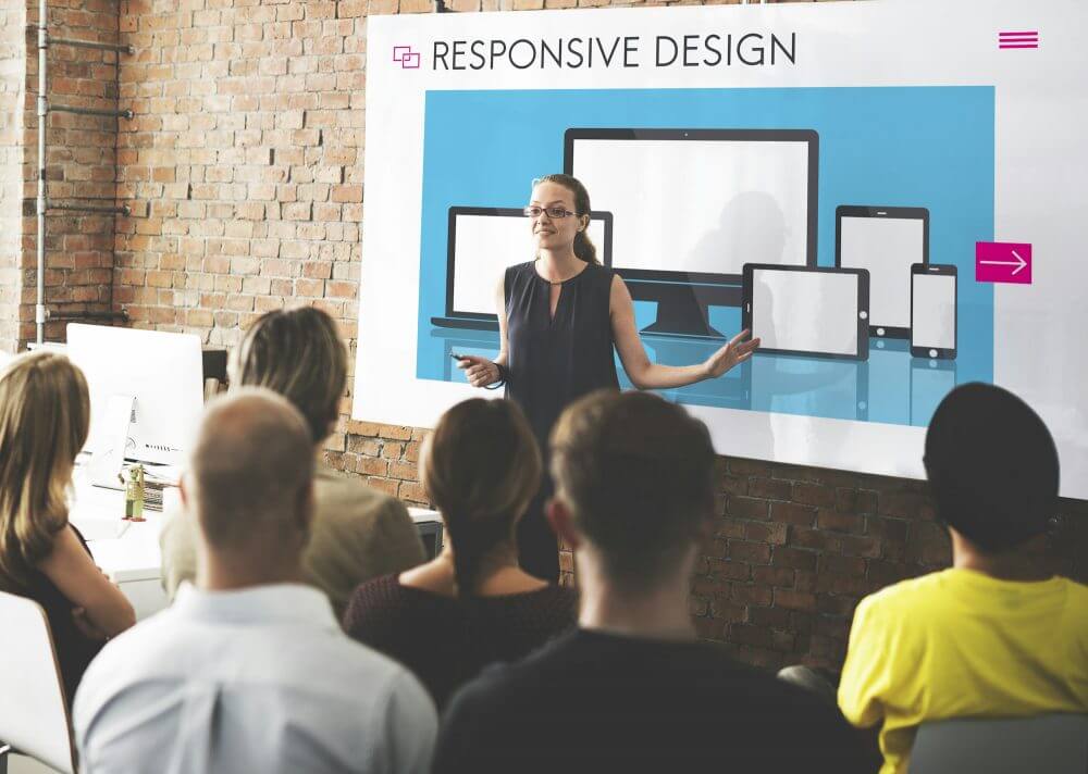 Frau hält einen Vortrag über responsive Design mit zuhörenden